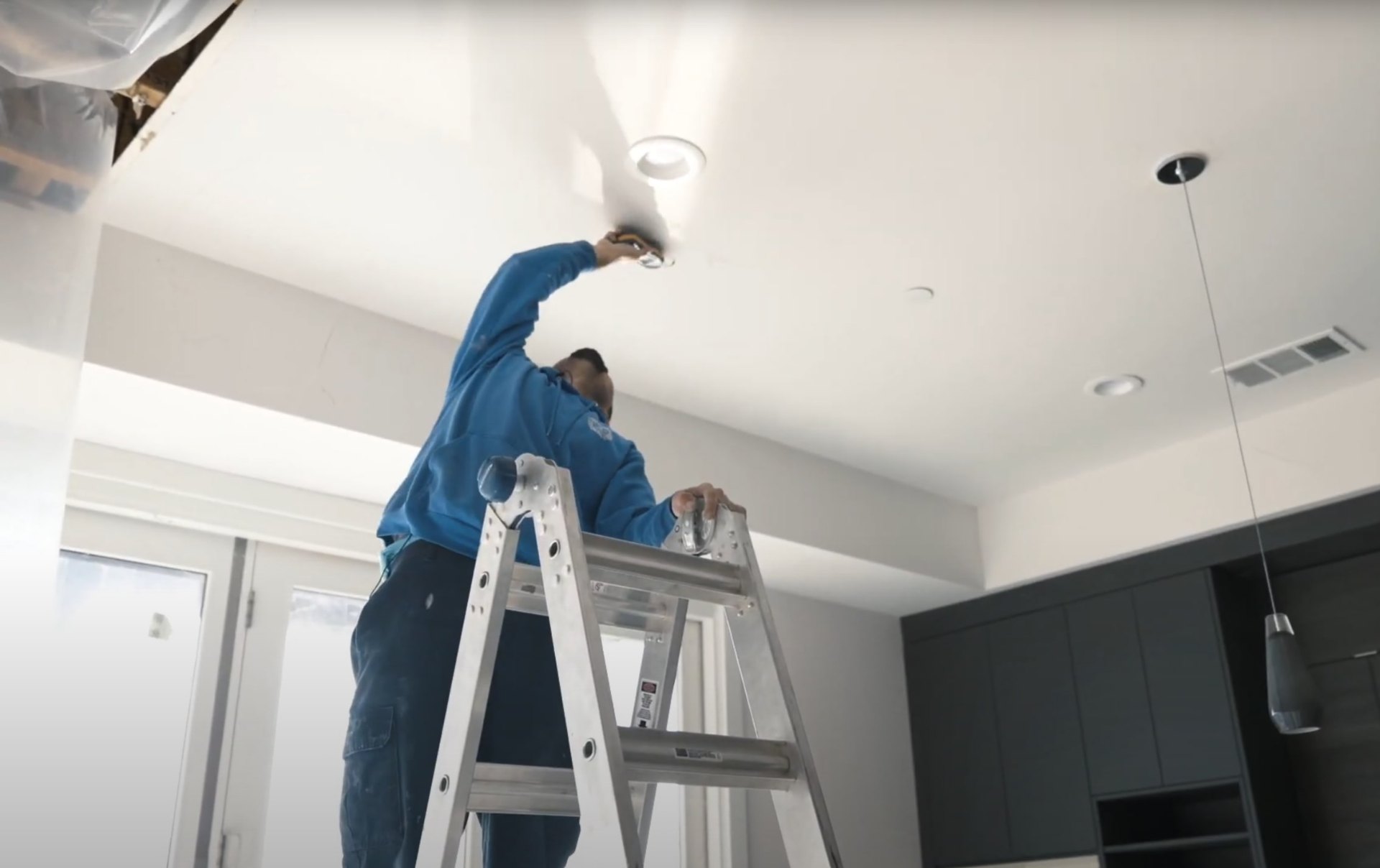 Expert technician performing water damage restoration services in La Porte Professional water damage restoration technician working on ceiling repairs